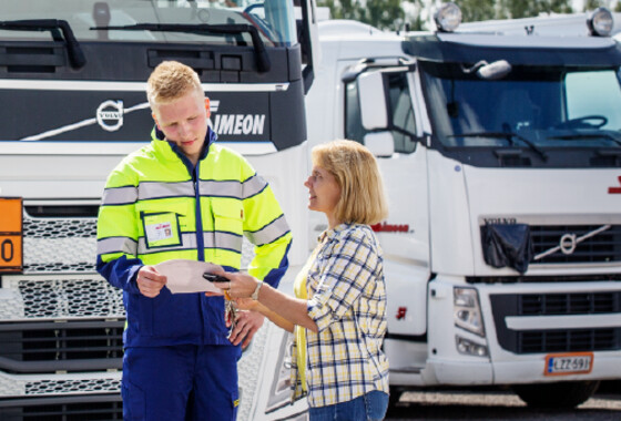 Kuljettaja ja toimihenkilö tutkivat papereita valkoiset kuorma-autot taustalla