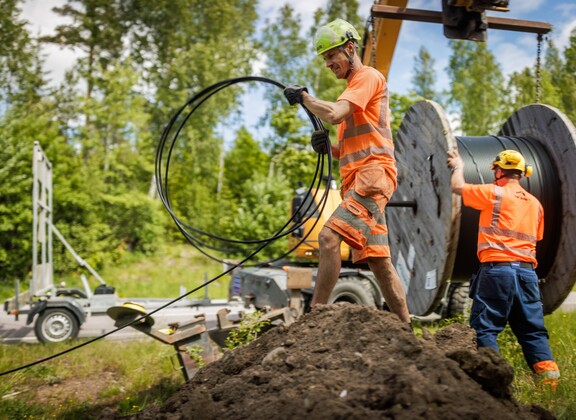Kaksi miestä asentamassa valokuitua