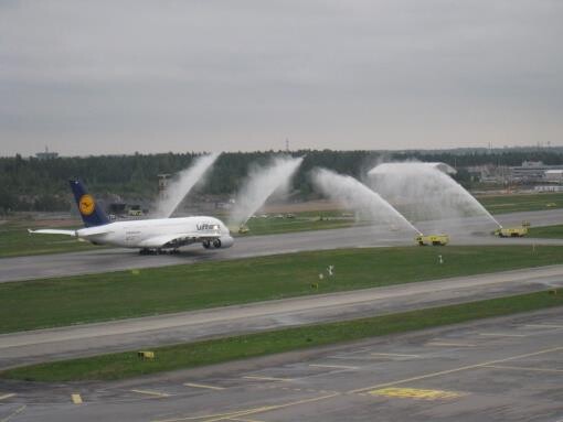 Paloautot ruiskuttavat vettä lentokoneen päälle lentokentällä